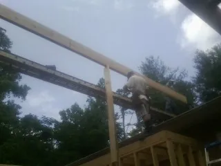 Carpenter setting a ridge beam over a new addition frame — Ice Dam Removal by Roofing Brothers in Delafield