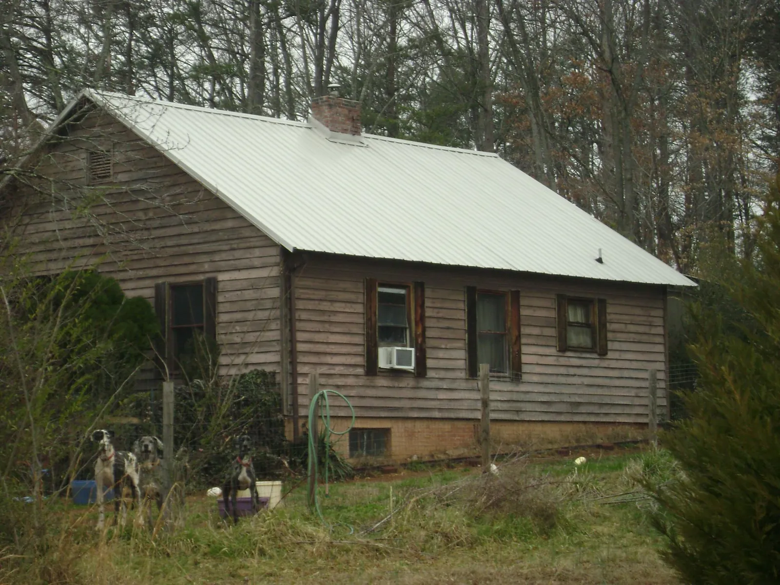 White metal roof on an old wood sided farmhouse, from a Metal Roof Installation job in Delafield